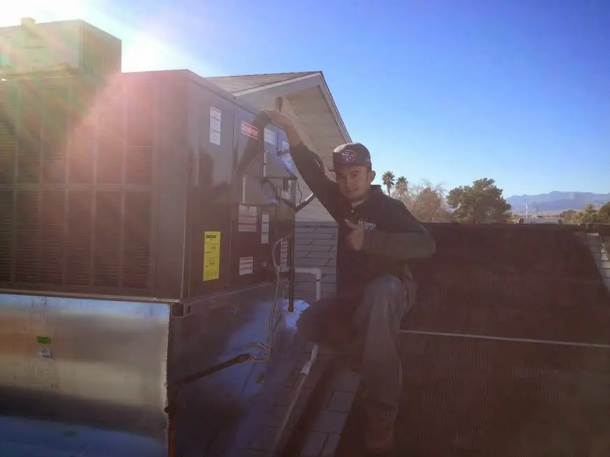 HVAC technician performing AC Tune-Up on a rooftop unit in Clarkston